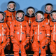 The crew of the Space Shuttle Discovery sport their pumpkin suits in 1998, including 77 year-old John Glenn, third from right, a former Mercury astronaut making his second trip to space.